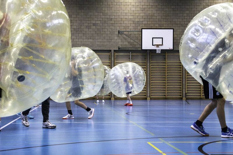 Jugendliche spielen Bubble-Fussball in einer Turnhalle